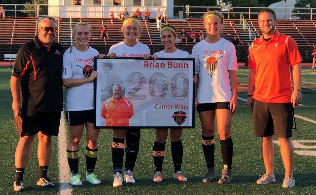 coaches and players holding a sign